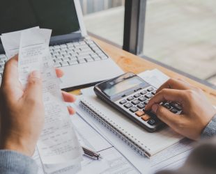 young-man-using-calculator-and-calculate-bills-in-home-office